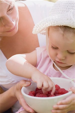 simsearch:659-03536938,k - Mother and young daughter eating raspberries Fotografie stock - Premium Royalty-Free, Codice: 659-03529820
