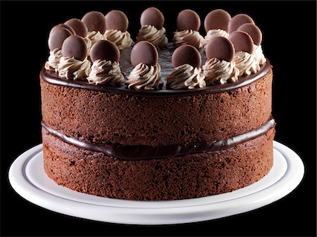 decorating a chocolate frosted cake - Two Layere Chocolate Cake; Black Background Stock Photo - Premium Royalty-Free, Code: 659-03521015