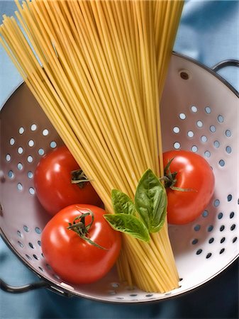 Spaghetti, tomatoes and basil in a colander Stock Photo - Premium Royalty-Free, Code: 659-03521075