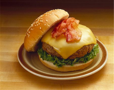 Bacon Cheeseburger on Sesame Seed Bun; On Plate Stock Photo - Premium Royalty-Free, Code: 659-03521447