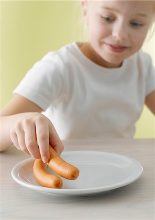 Blond girl eating frankfurters Stock Photo - Premium Royalty-Free, Code: 659-03521588