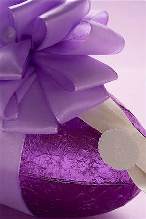 simsearch:659-07027219,k - Un oeuf de Pâques au chocolat dans du papier violet avec noeud violet Photographie de stock - Premium Libres de Droits, Code: 659-03521622