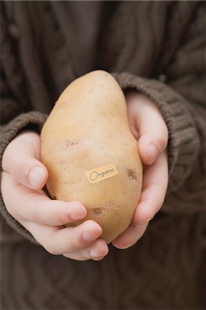 Girl holding an organic potato Stock Photo - Premium Royalty-Free, Code: 659-03521662