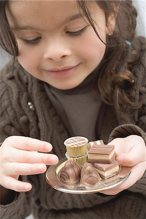 simsearch:659-06152936,k - Fille prendre un chocolat d'un petit plateau de chocolats Photographie de stock - Premium Libres de Droits, Code: 659-03521675