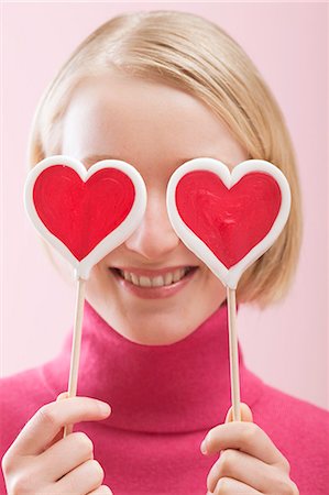 Love is blind: woman with heart-shaped lollipops in front of her eyes Foto de stock - Sin royalties Premium, Código: 659-03521769