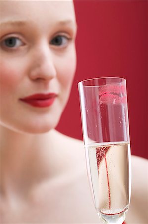 Young woman holding glass of sparkling wine with lipstick mark Stock Photo - Premium Royalty-Free, Code: 659-03521781