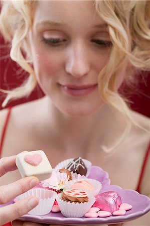 simsearch:659-03521588,k - Young woman eating chocolates and sweets Fotografie stock - Premium Royalty-Free, Codice: 659-03521794