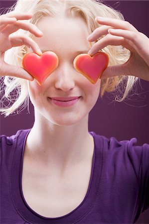 Young woman holding hearts in front of her eyes Fotografie stock - Premium Royalty-Free, Codice: 659-03521807