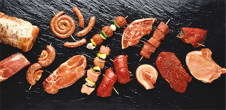 raw sausage - Assorted meats and sausages on hot stone grill Stock Photo - Premium Royalty-Free, Code: 659-03521829