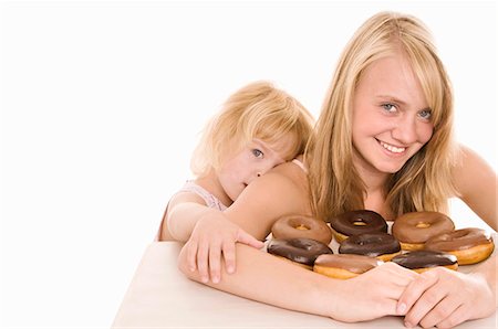 Two girls with doughnuts Stock Photo - Premium Royalty-Free, Code: 659-03522475