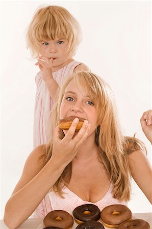 simsearch:659-01867426,k - Deux filles manger des beignes Photographie de stock - Premium Libres de Droits, Code: 659-03522476