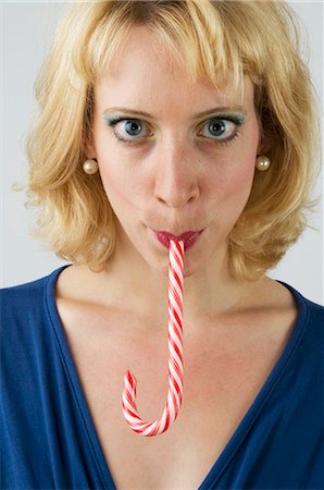 decollete - Blond woman with a candy cane in her mouth Stock Photo - Premium Royalty-Free, Code: 659-03522491