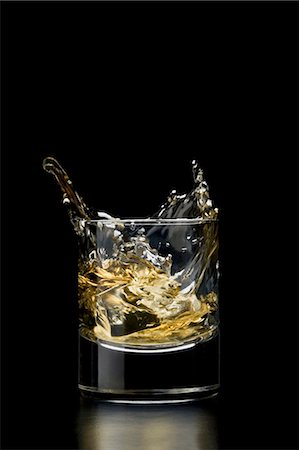 Ice cube falling into a glass of whisky Stock Photo - Premium Royalty-Free, Code: 659-03522693