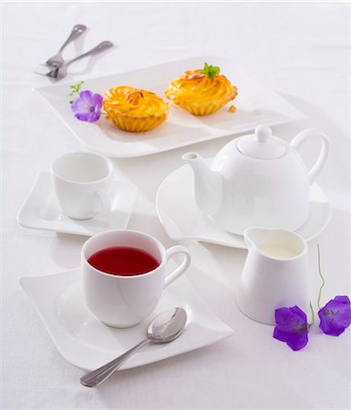 A cup of fruit tea, tea things and small cakes Foto de stock - Sin royalties Premium, Código: 659-03522727