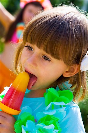 Little girl licking an ice lolly at a children's party Foto de stock - Sin royalties Premium, Código: 659-03522722