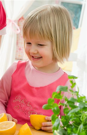 Small girl with lemons in a kitchen Stock Photo - Premium Royalty-Free, Code: 659-03523096