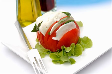 A tomato with mozzarella and basil Stock Photo - Premium Royalty-Free, Code: 659-03523123