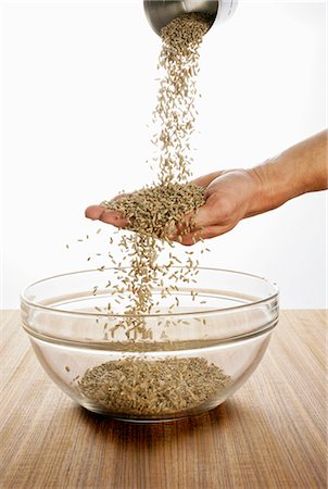 Someone pouring rye over their hand into a glass bowl Foto de stock - Sin royalties Premium, Código: 659-03523345