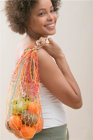 string bag - Young woman with a string bag full of fruit Stock Photo - Premium Royalty-Free, Code: 659-03523385