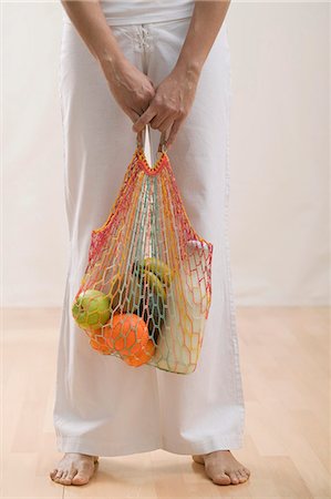 string bag - Young woman with string bag full of groceries Stock Photo - Premium Royalty-Free, Code: 659-03523387