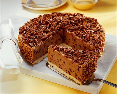 Hazelnut chocolate cheesecake with grated chocolate, a piece cut Foto de stock - Sin royalties Premium, Código: 659-03523480