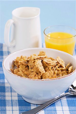 Bowl of wholemeal cornflakes and a glass of orange juice Stock Photo - Premium Royalty-Free, Code: 659-03523654