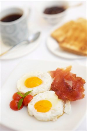Fried eggs with bacon and tomatoes, toast and coffee Stock Photo - Premium Royalty-Free, Code: 659-03523678