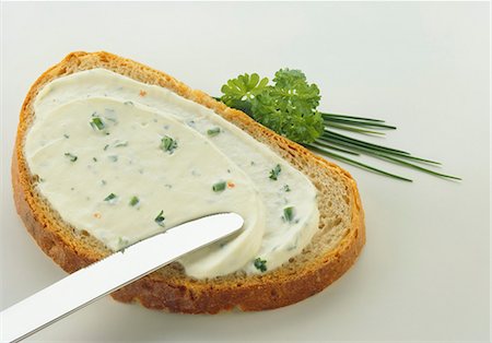 spreading - A slice of bread with herb soft cheese Stock Photo - Premium Royalty-Free, Code: 659-03534312