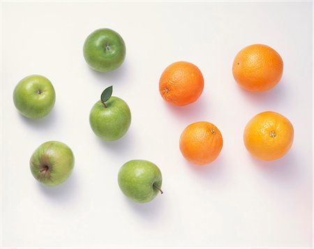 Five green apples & four oranges against a white background Stock Photo - Premium Royalty-Free, Code: 659-03534454