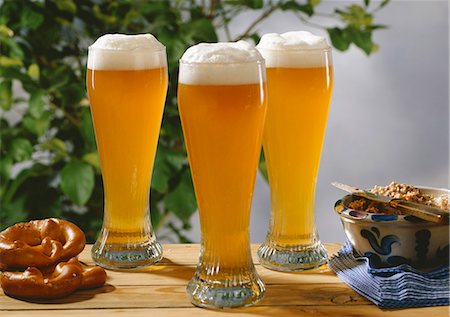 Three glasses of wheat beer on wooden table with pretzels & lard Foto de stock - Sin royalties Premium, Código: 659-03534579