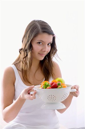Girl holding a kitchen sieve with fresh fruit Stock Photo - Premium Royalty-Free, Code: 659-03534815