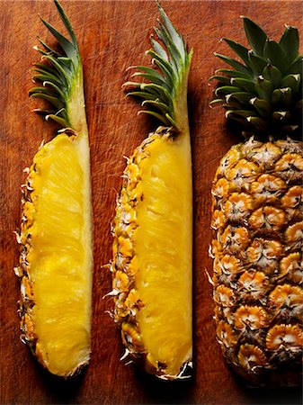 Wedges of pineapple on wooden background Stock Photo - Premium Royalty-Free, Code: 659-03534882