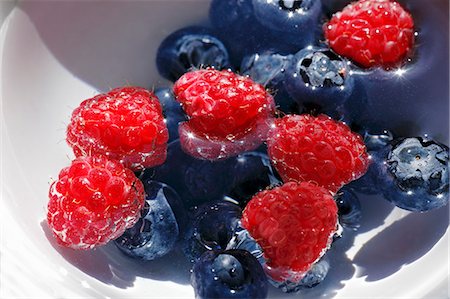 Raspberries and blueberries in a bowl of water Stock Photo - Premium Royalty-Free, Code: 659-03534897