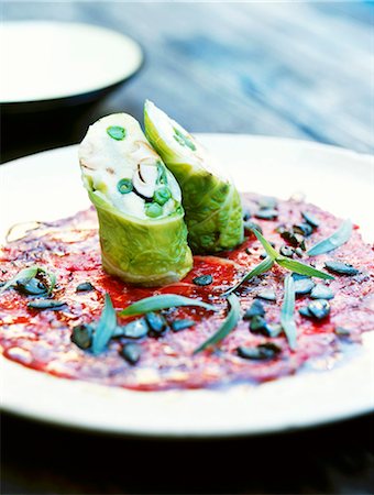 Vegetable polenta wrapped in savoy cabbage on a beef carpaccio Fotografie stock - Premium Royalty-Free, Codice: 659-03535224