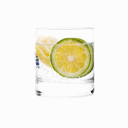 simsearch:659-06306561,k - Un verre d'eau avec des tranches de citron vert Photographie de stock - Premium Libres de Droits, Code: 659-03535263