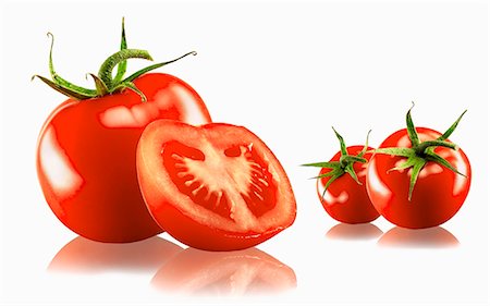 simsearch:659-03531992,k - Three whole and one halved tomato with a white background and reflection Stock Photo - Premium Royalty-Free, Code: 659-03535375