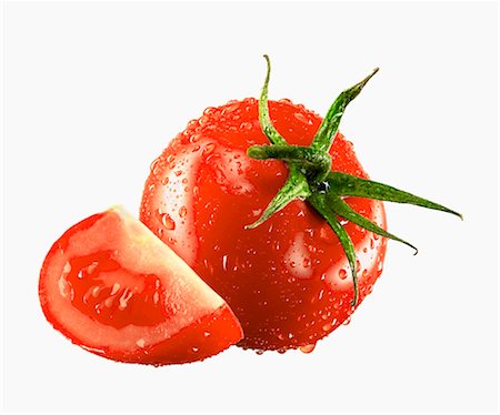 One whole and one tomato wedge with drops of water Stock Photo - Premium Royalty-Free, Code: 659-03535378