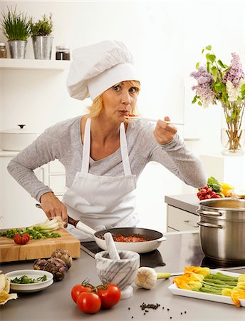 Hobby cook blowing on a spoon before tasting the cooking Fotografie stock - Premium Royalty-Free, Codice: 659-03535433