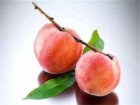 peach (fruit) - Yellow Florentine peaches on branch Foto de stock - Sin royalties Premium, Código: 659-03535670