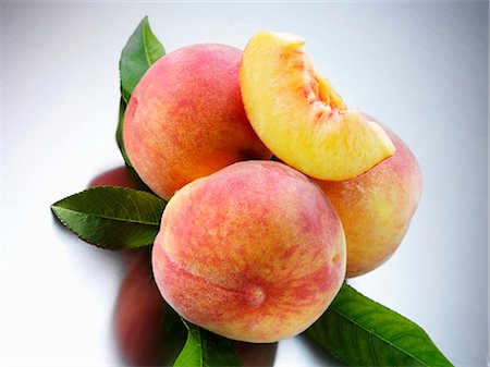 fresh peach - Yellow Florentine peaches with leaves Foto de stock - Sin royalties Premium, Código: 659-03535671