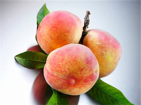 fresh peach - Yellow Florentine peaches with leaves Foto de stock - Sin royalties Premium, Código: 659-03535672