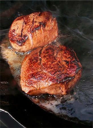 sizzling steak - Biftecks de filet chaud dans la poêle à frire Photographie de stock - Premium Libres de Droits, Code: 659-03535688