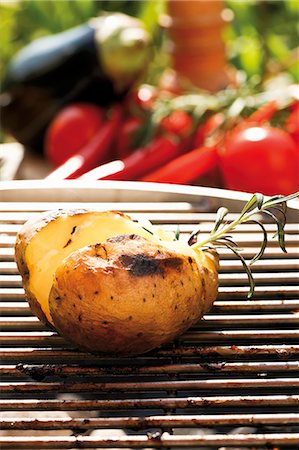 simsearch:659-03537206,k - Barbecued potato on barbecue, vegetables in background Foto de stock - Sin royalties Premium, Código: 659-03535950