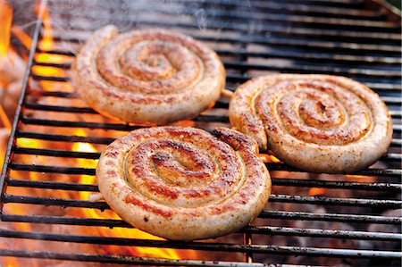 simsearch:659-07069540,k - Coiled sausages on barbecue rack Foto de stock - Sin royalties Premium, Código: 659-03535968