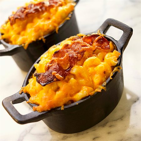 ferro fundido - Two Individual Pots of Macaroni and Cheese with Bacon Foto de stock - Royalty Free Premium, Número: 659-03536187