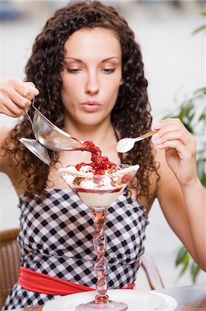 sundae - Woman pouring hot raspberries over vanilla ice cream Stock Photo - Premium Royalty-Free, Code: 659-03536218