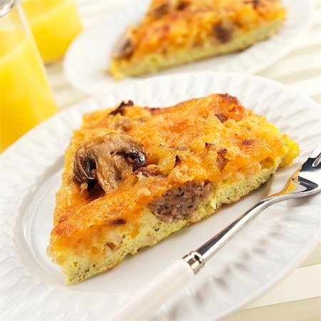 Slice of Mushroom Sausage Frittata on White Plate; Fork Stock Photo - Premium Royalty-Free, Code: 659-03536212