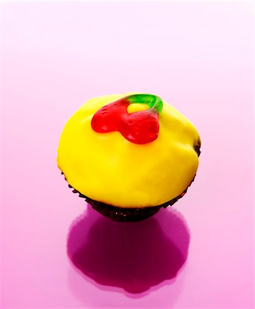 Muffin with yellow icing and jelly cherries Stock Photo - Premium Royalty-Free, Code: 659-03536224