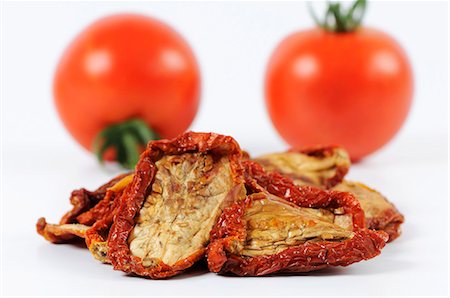 sundried tomato - Dried tomatoes in front of fresh tomatoes Foto de stock - Sin royalties Premium, Código: 659-03536301