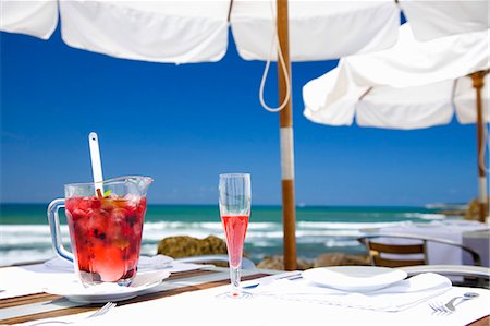 Sangria with berries in jug & sparkling wine glass on table by sea Stock Photo - Premium Royalty-Free, Code: 659-03536388